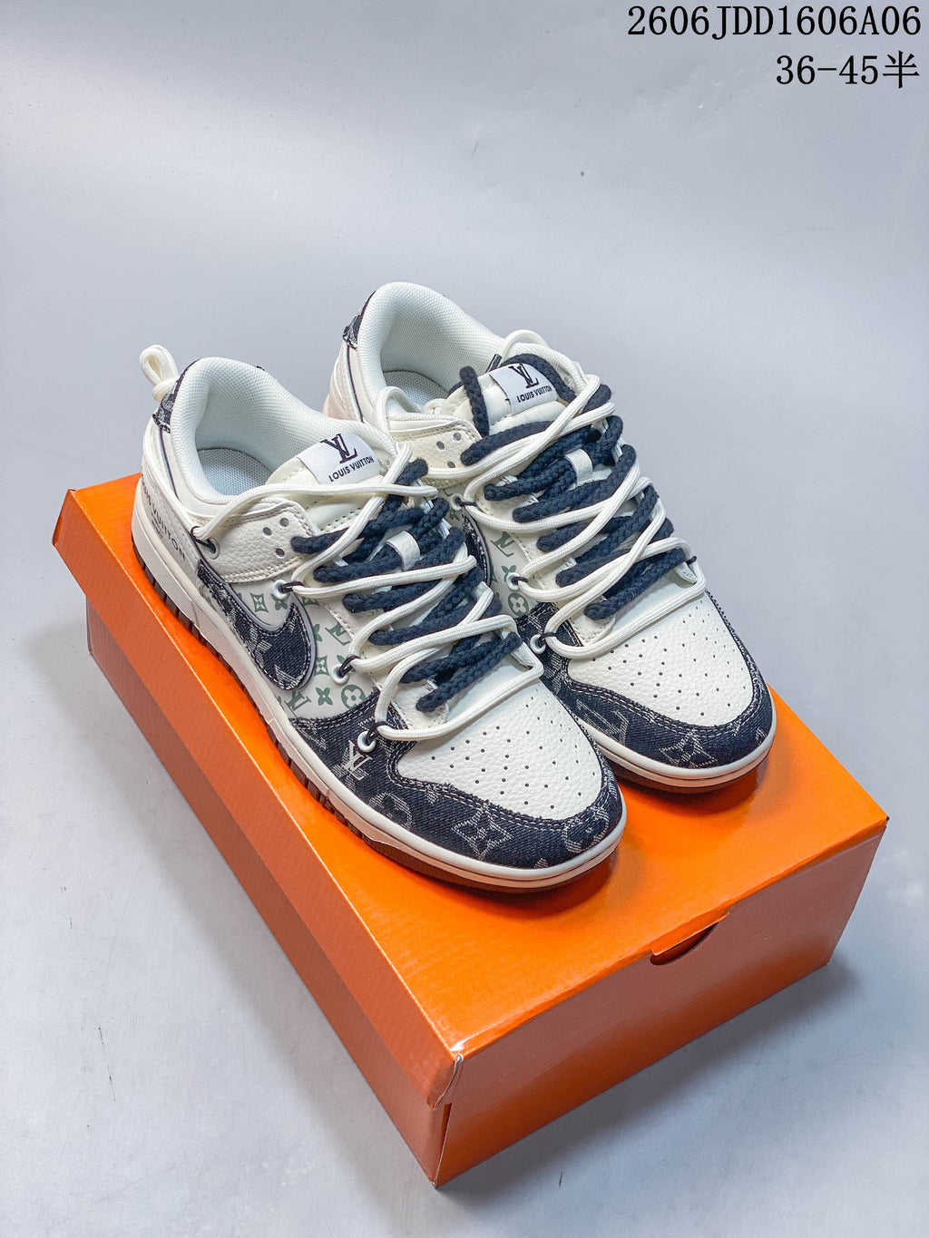 Cream and navy patterned low-top sneakers shown from above on an orange shoe box.