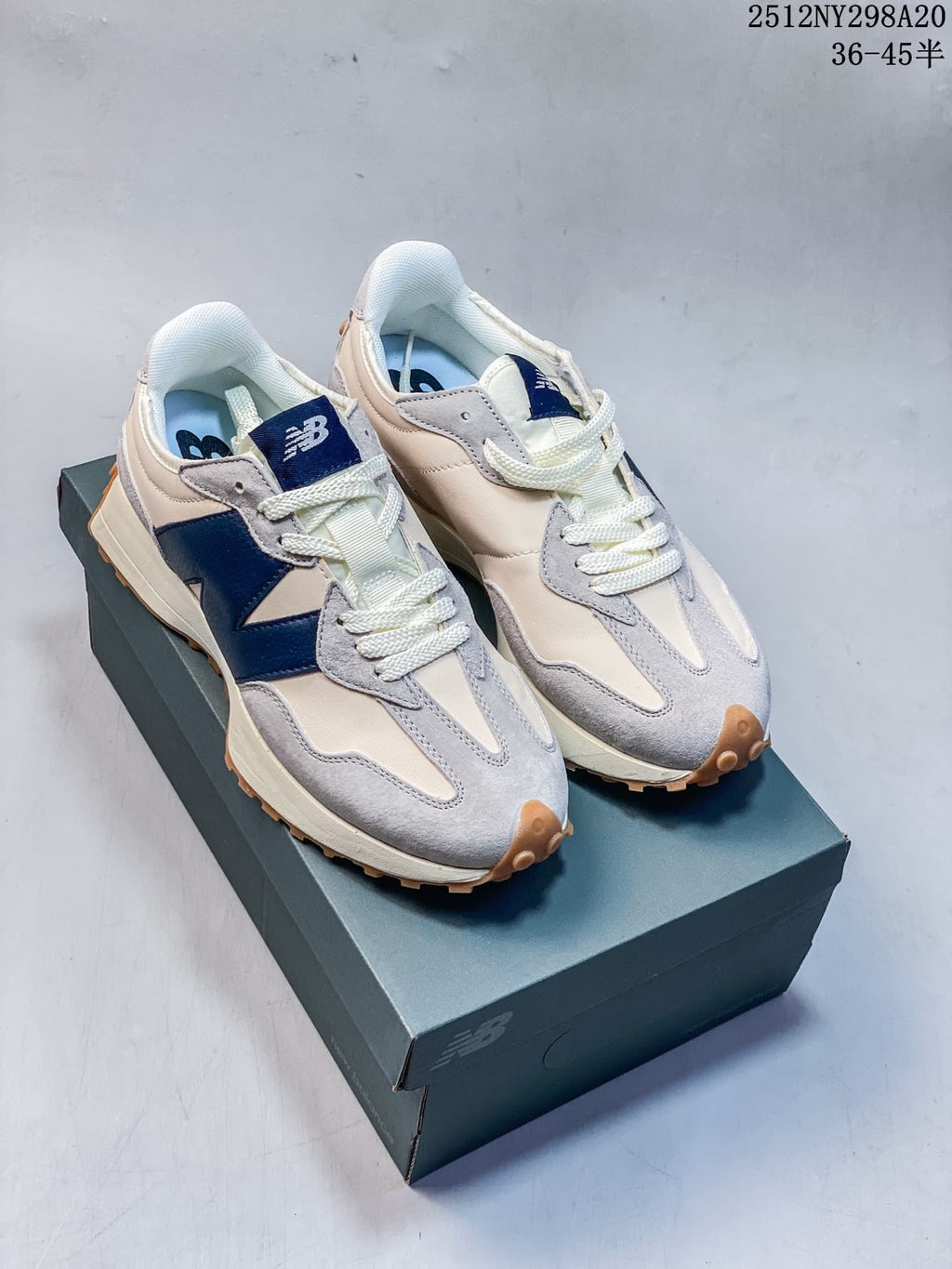 Pair of cream, gray and navy New Balance 327 sneakers displayed on a shoe box.