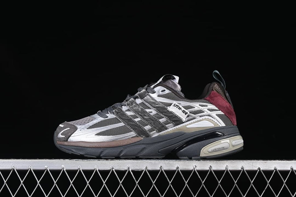 Side view of the charcoal and silver-gray sneaker with burgundy heel accents.