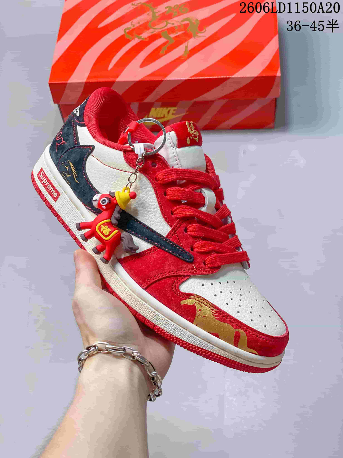 Angled view of a red, white, and navy low-top sneaker with a dangling charm