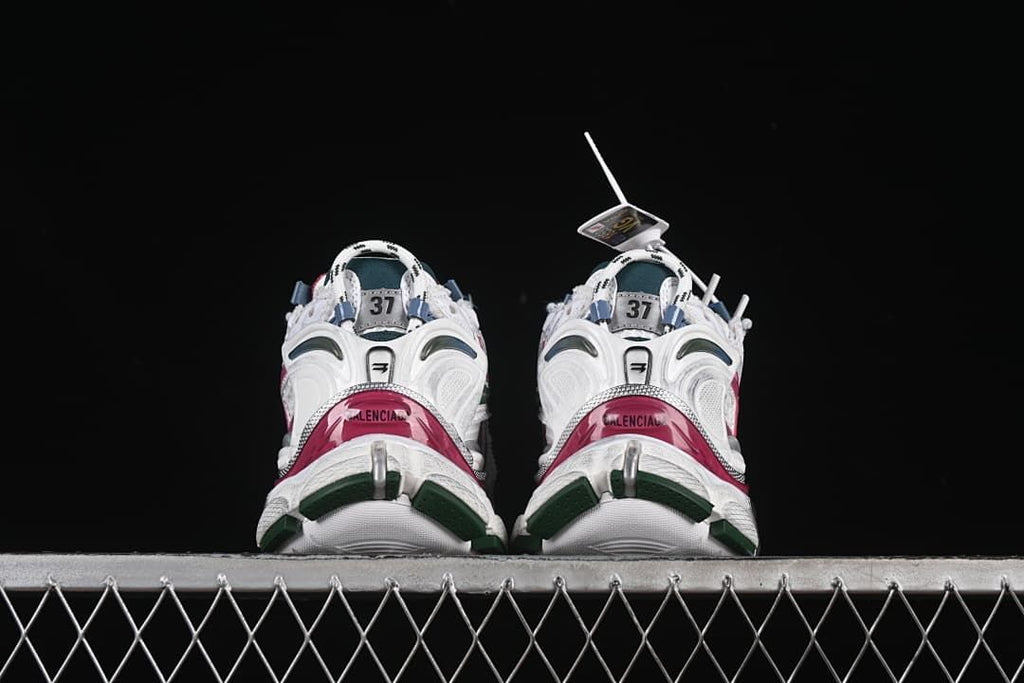 Rear view of both sneakers with pink heel panels and green outsole details