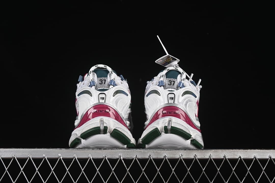 Rear view of both sneakers with pink heel panels and green outsole details