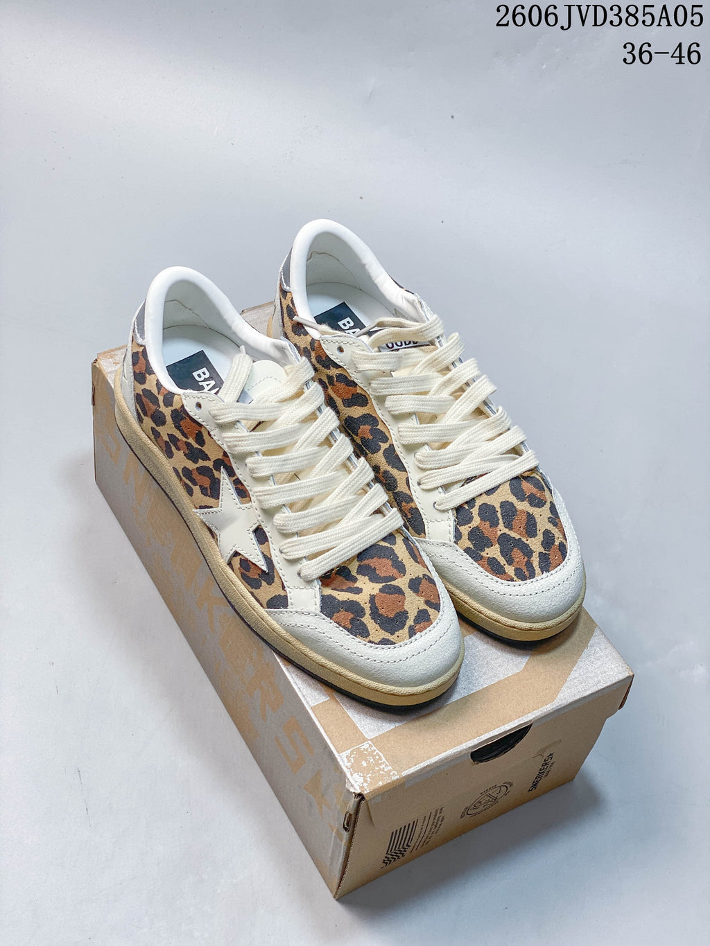 Pair of leopard-print Golden Goose Super-Star sneakers with cream trim and laces, shown on a shoe box.