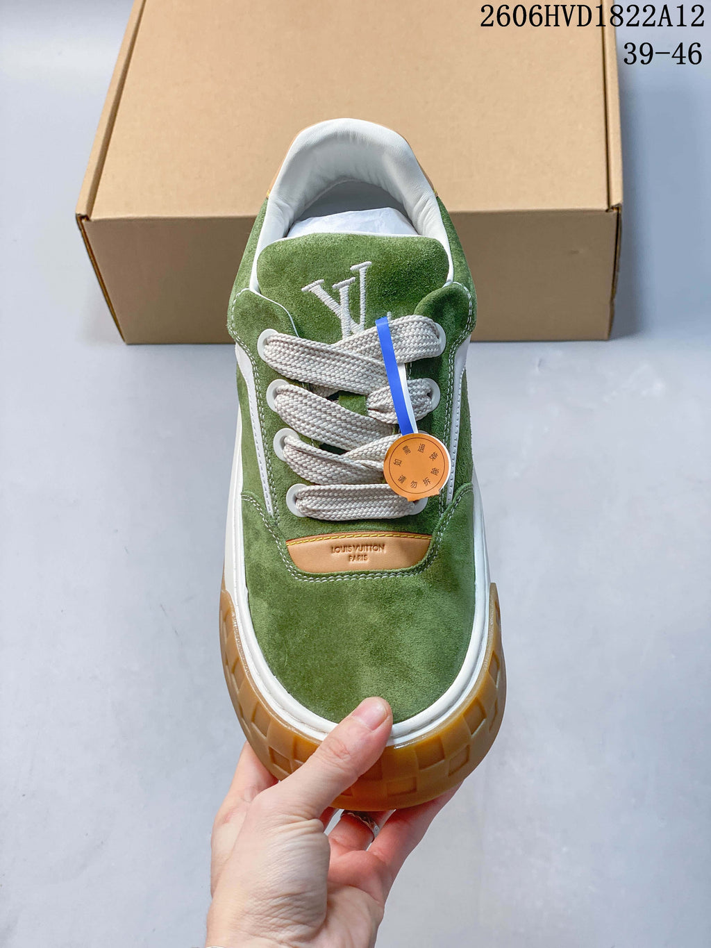 Front view of the green lace-up sneaker with tan accent and textured gum-colored toe edge