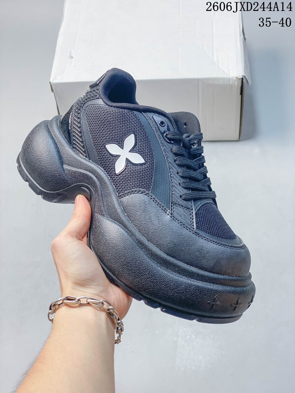 Side view of a charcoal SMFK sneaker with a white emblem and sculpted sole.
