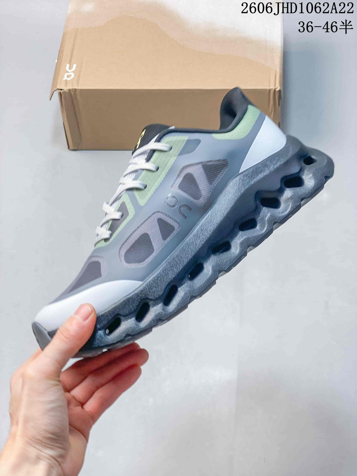 Side view of a gray On Cloudtilt Remix sneaker with lime accents and a sculpted sole.