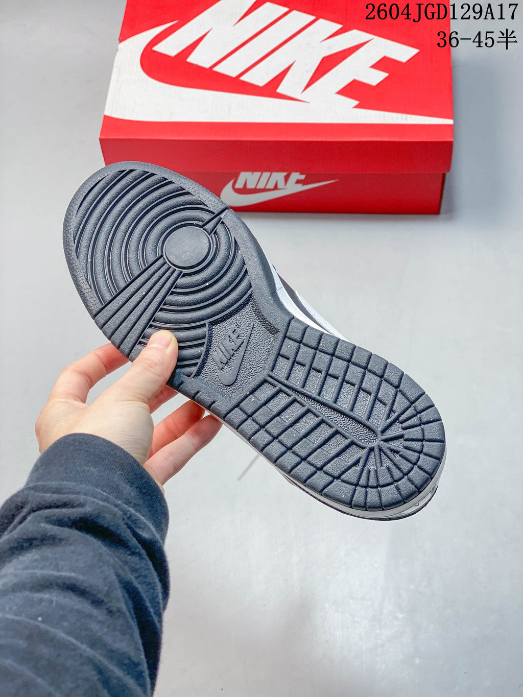 Underside of a dark gray sneaker showing its patterned outsole