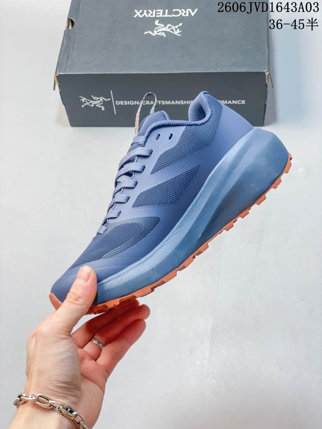 Side view of a blue low-top shoe with orange outsole
