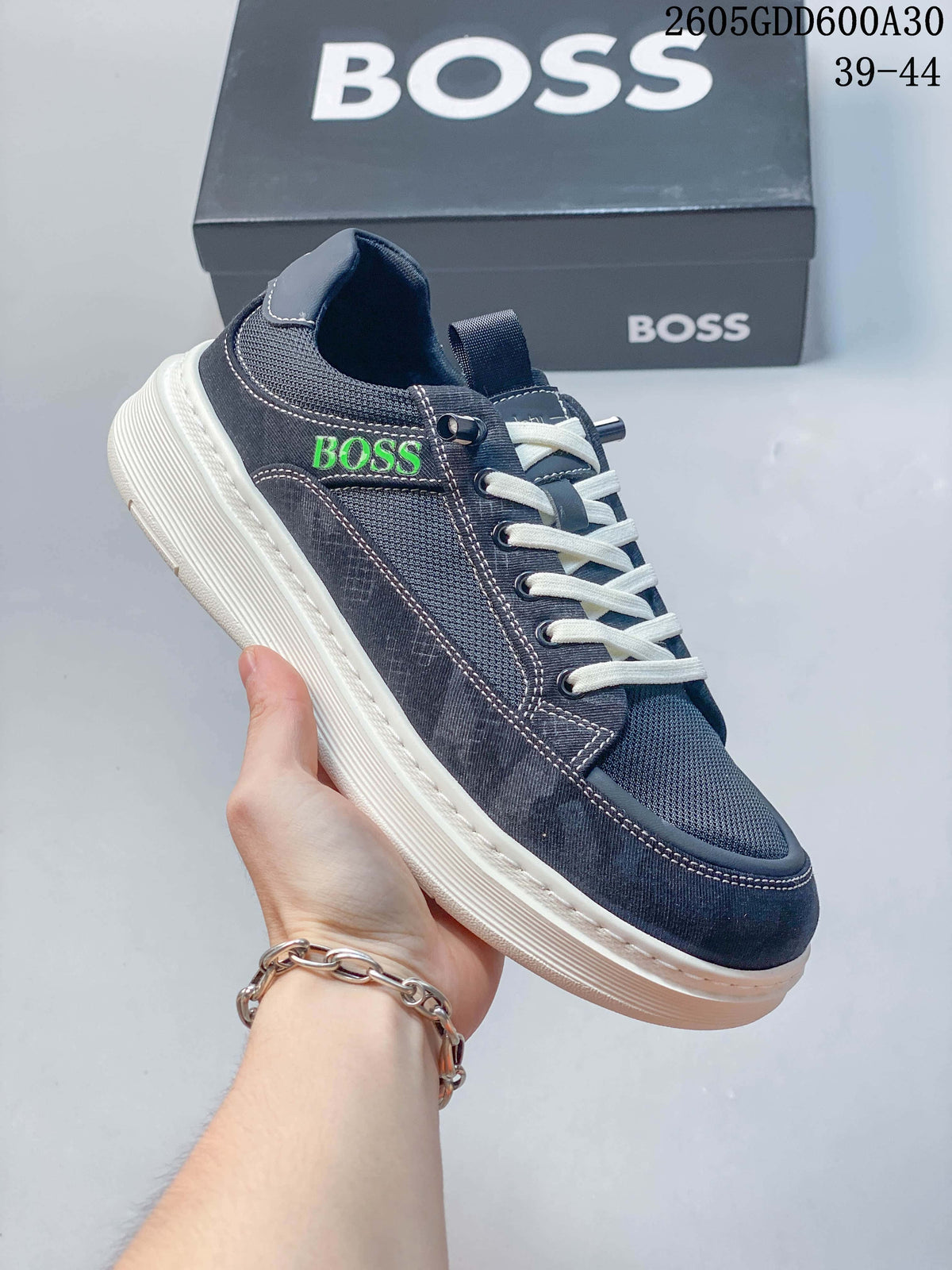 Angled side view of a navy sneaker with green BOSS lettering, white laces, and an off-white sole; image overlay states sizes 39–44.