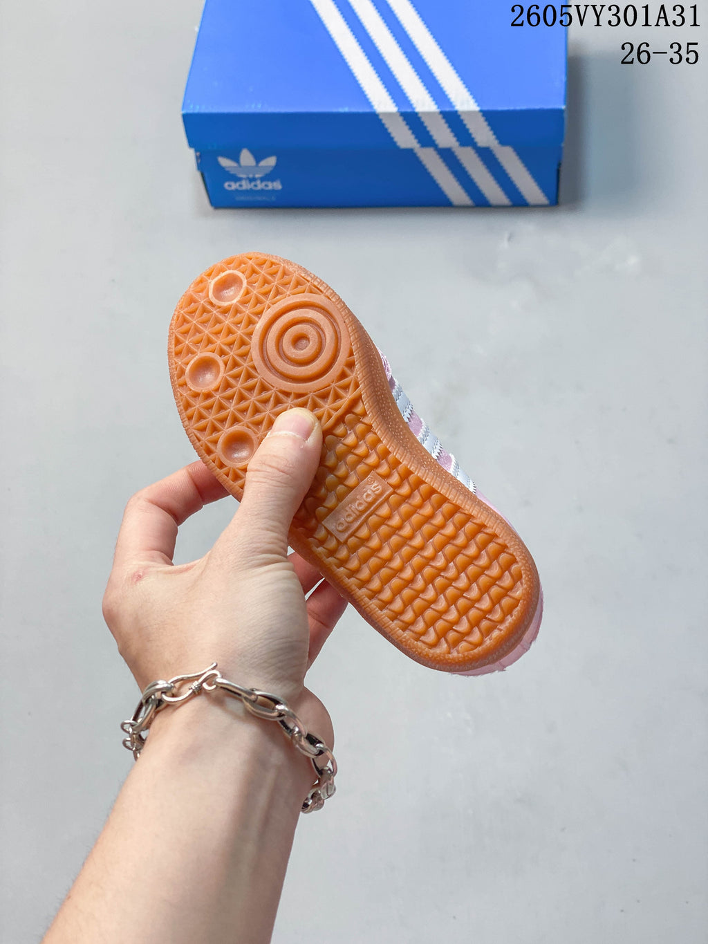 Close-up of the textured gum-colored outsole on a pink kids’ shoe.