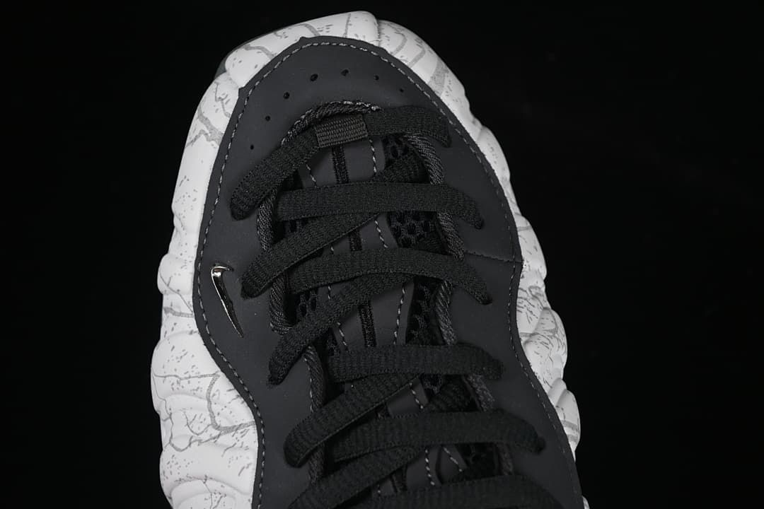 Top-down close-up of black laces and the patterned toe.