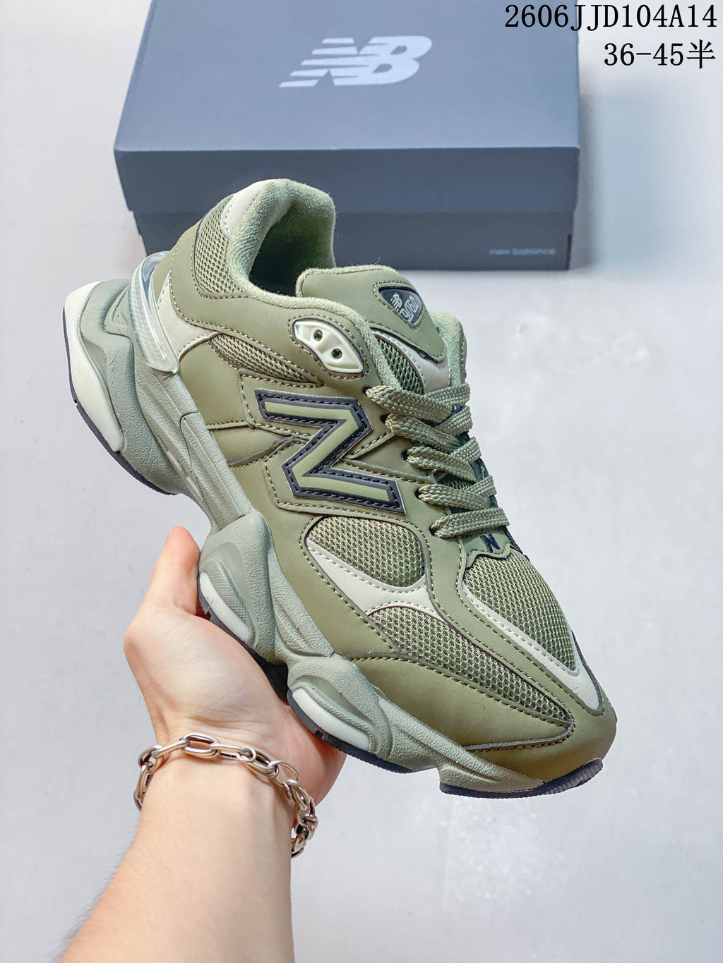Olive green New Balance 9060 sneaker with mesh panels, layered overlays and a chunky sole.