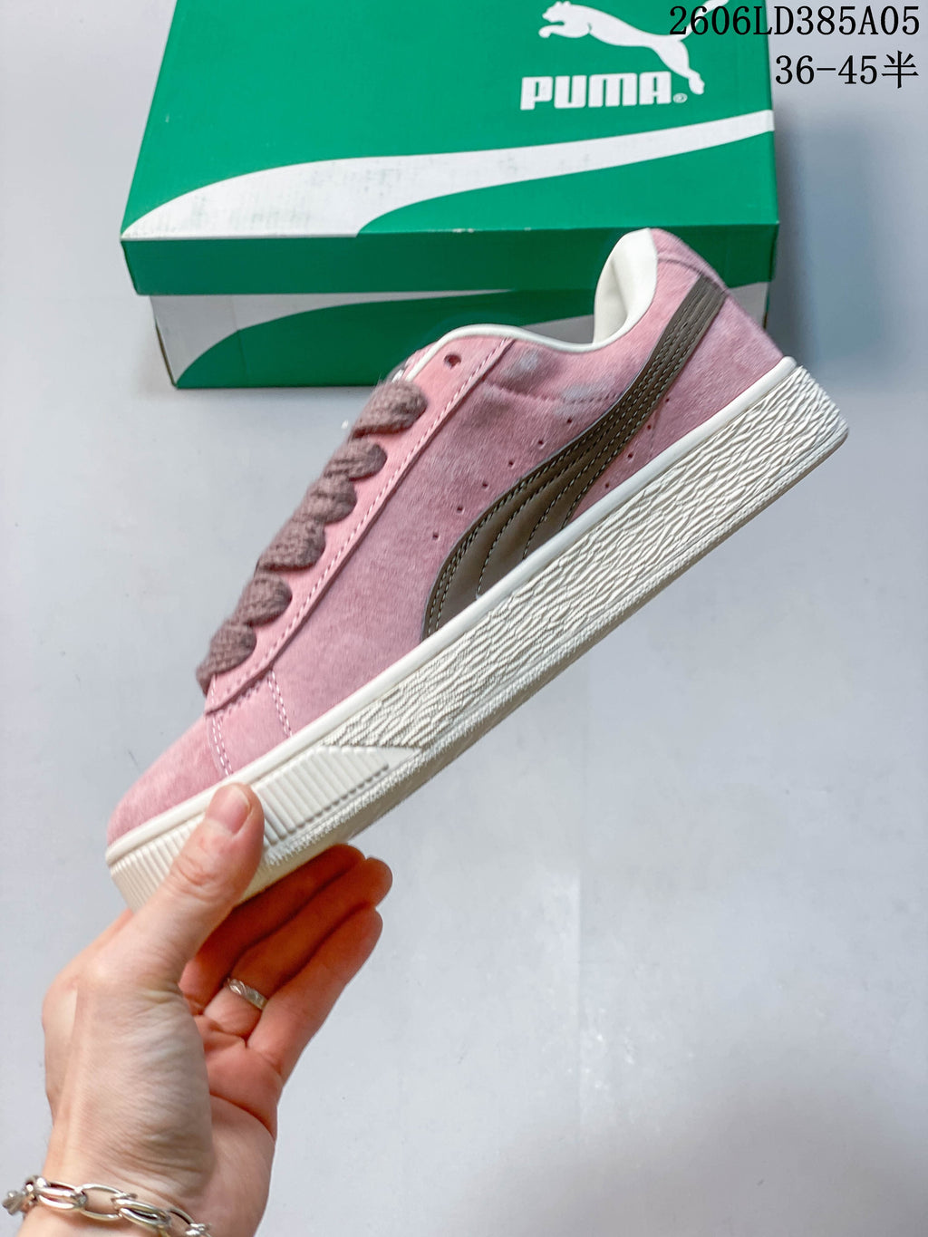 Side view of a pink PUMA sneaker with a contrasting stripe and platform-style sole