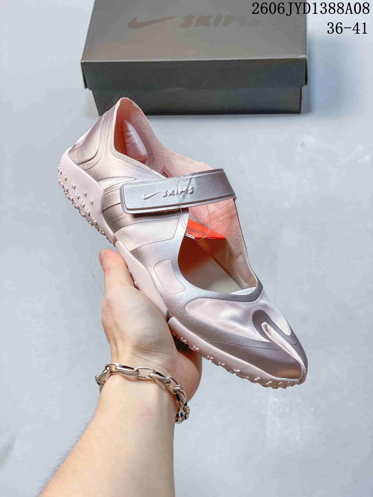 Angled view of a pink Nike Air Rift shoe with a wide strap