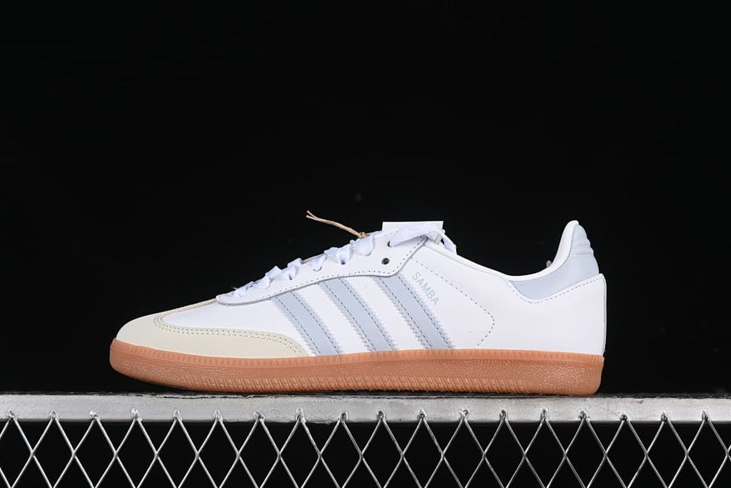 Side view of white adidas Samba OG sneakers with grey stripes, cream toe overlay, and gum sole