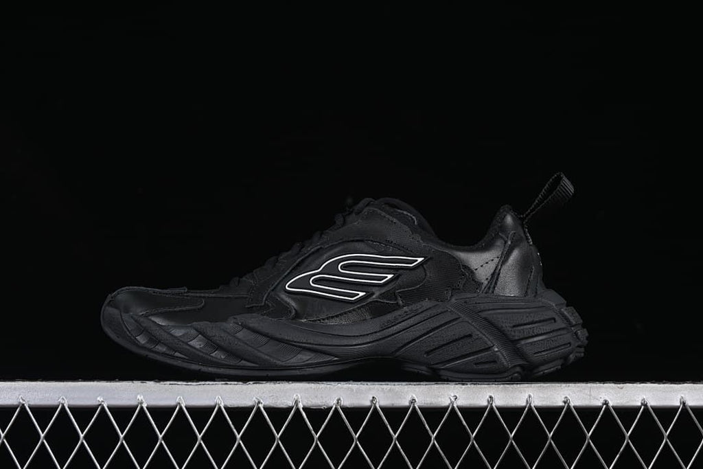 Black low-top sneaker shown in profile