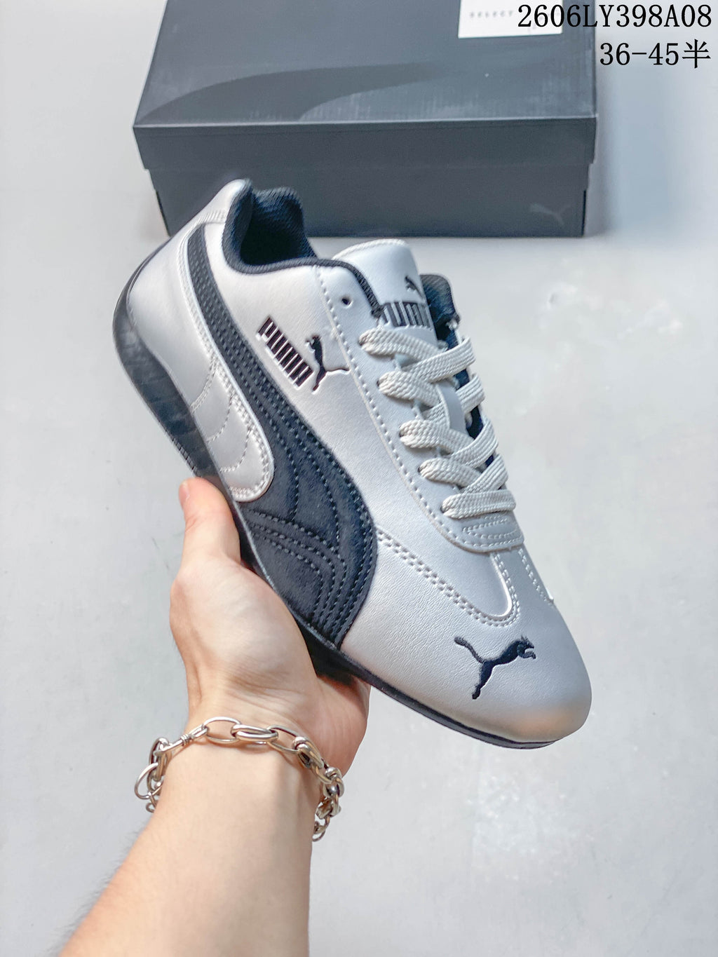 Close-up of a silver PUMA Speedcat OG sneaker with dark side stripe