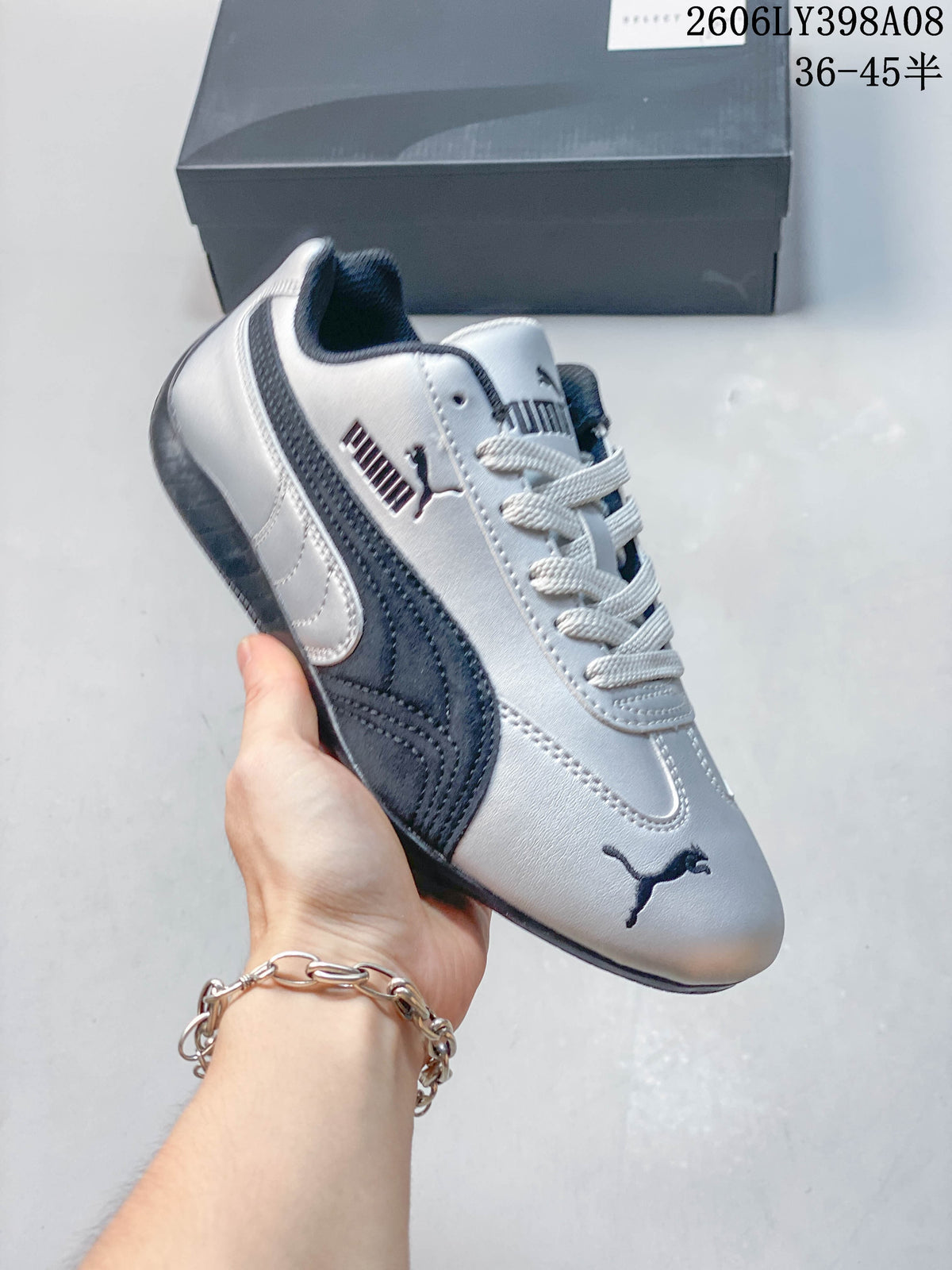 Close-up of a silver PUMA Speedcat OG sneaker with dark side stripe