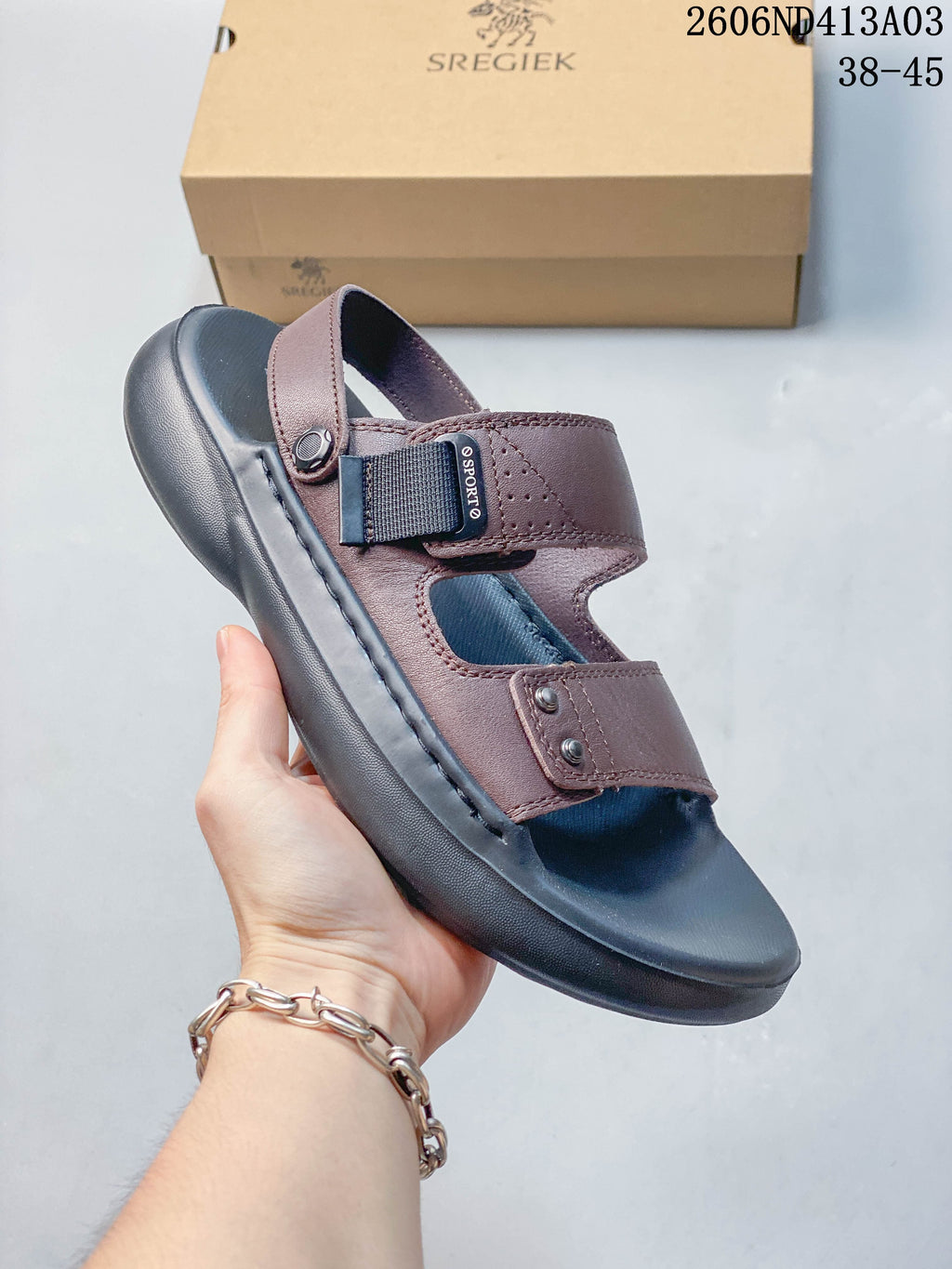 Angled view of a brown sandal showing its adjustable strap and open-toe design.