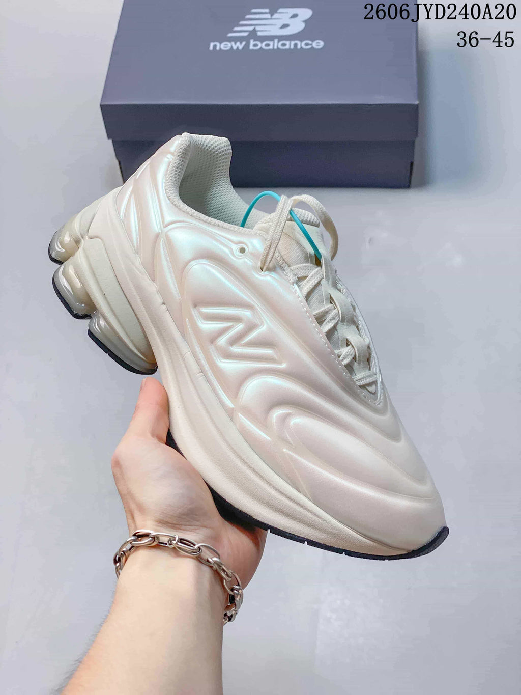 Angled side view of a pearl-white New Balance sneaker with a sculpted upper and chunky sole.