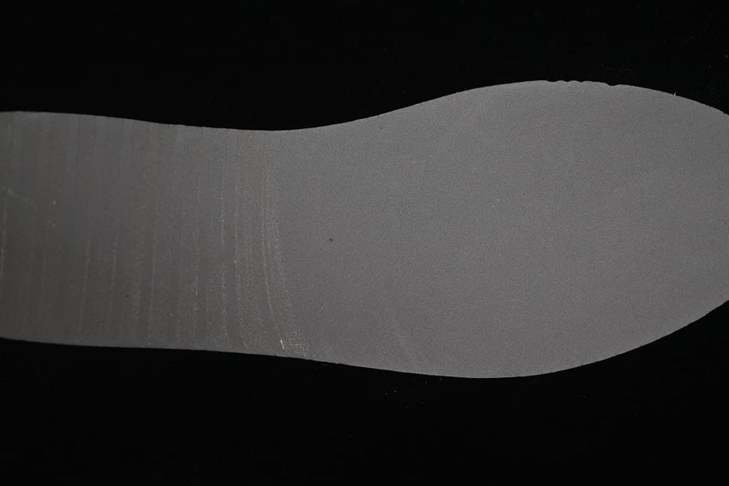 Gray outsole insert photographed against a black background