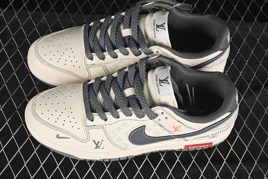 Top view of a pair of cream low-top sneakers with dark laces, perforated toe boxes, and printed panels