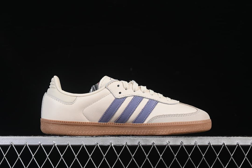 Side profile of the cream sneaker with blue stripes and gum sole