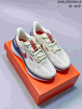 Pair of cream Nike Air running shoes with red and blue accents on an orange shoebox