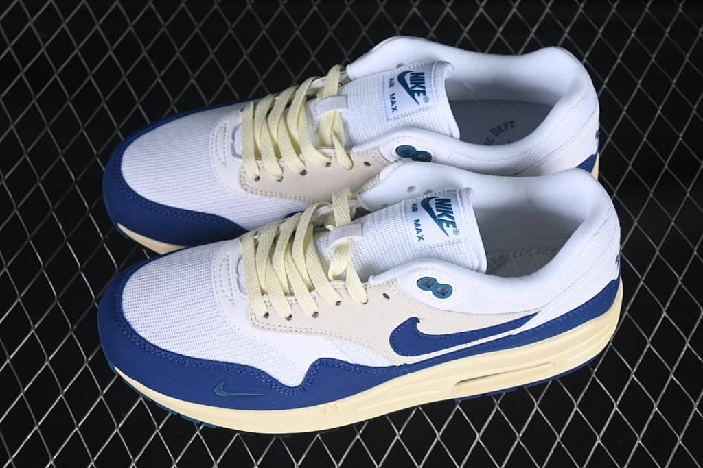 Pair of white, navy and cream Nike Air Max 1 sneakers