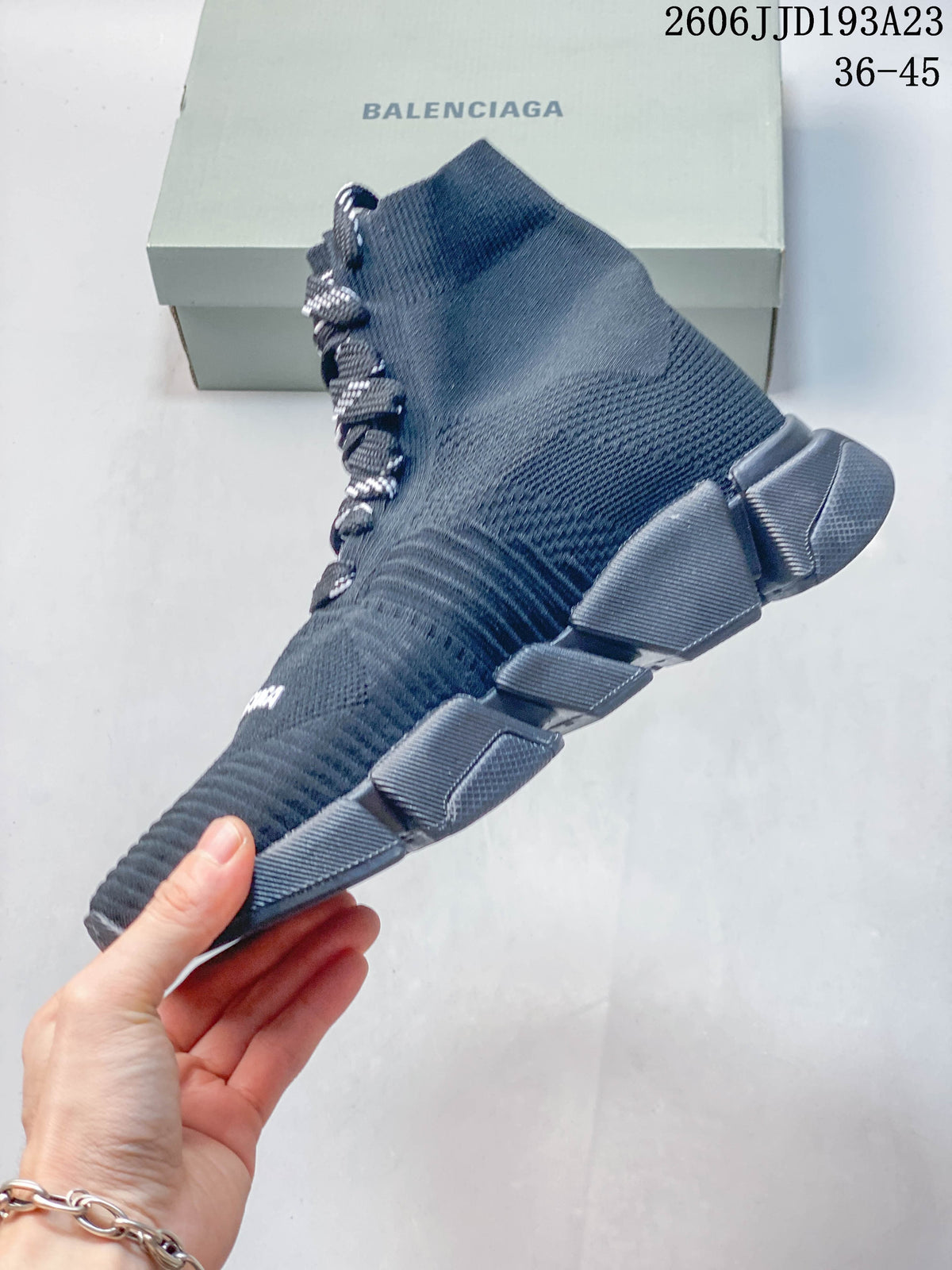 Side view of a navy sock-style sneaker with a chunky segmented sole