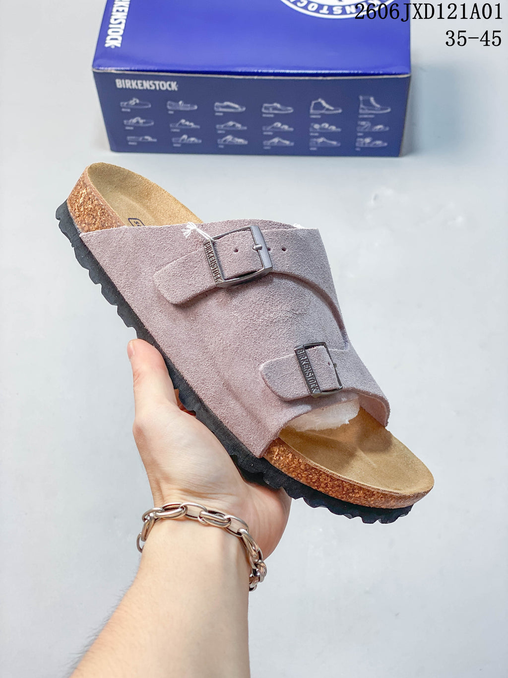 Side view of a muted mauve two-strap sandal with adjustable buckles and a dark outsole.
