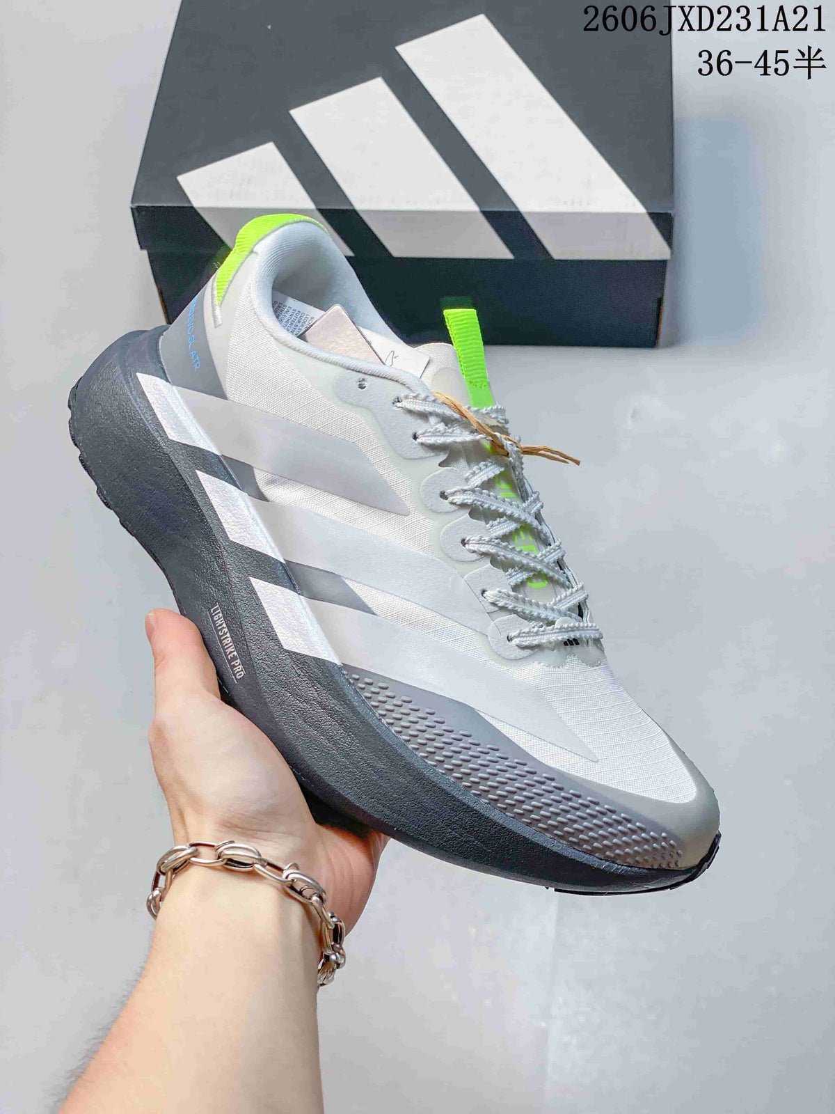 Side view of a white and grey running shoe with a sculpted dark grey sole and lime accents.