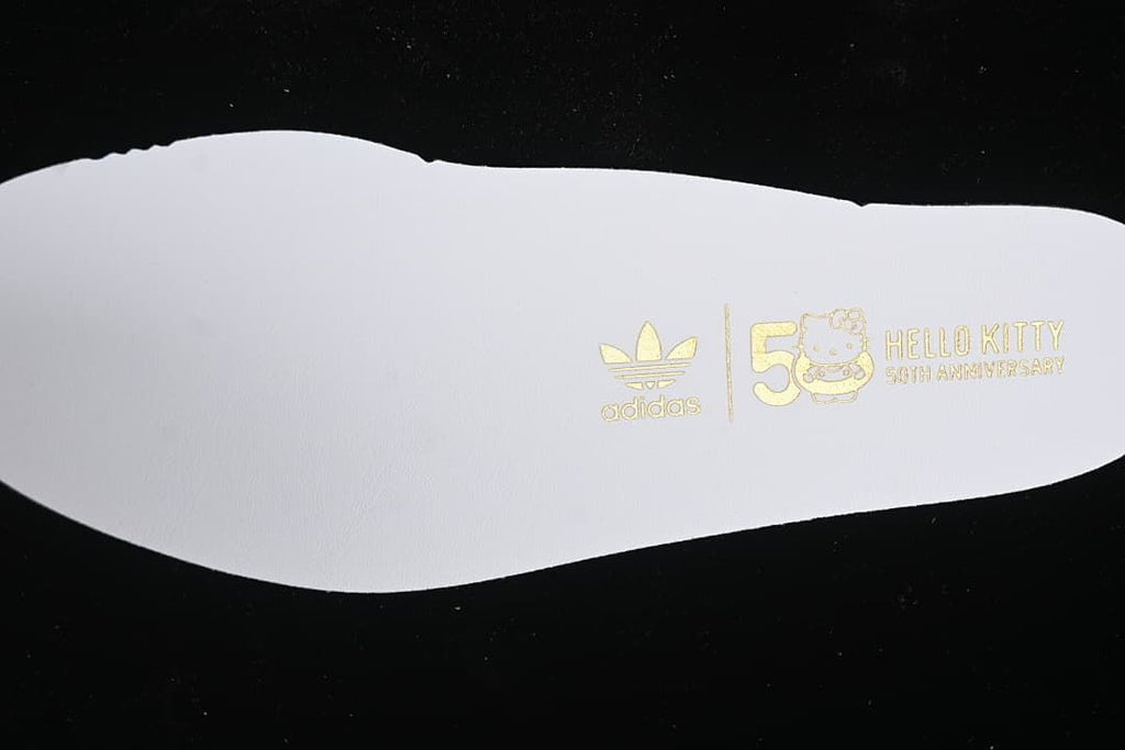 White insole printed with Adidas and Hello Kitty 50th anniversary branding.