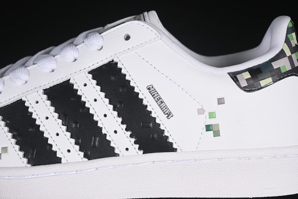 Close-up of black stripes and pixel accents on the white sneaker side