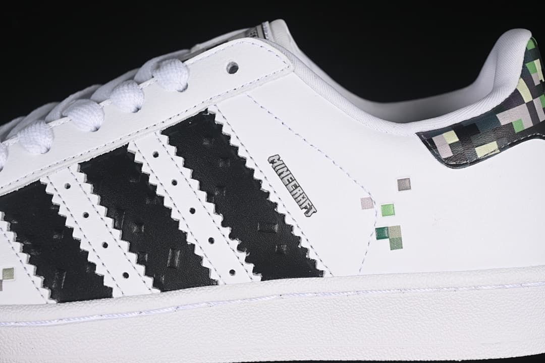 Close-up of black stripes and pixel accents on the white sneaker side