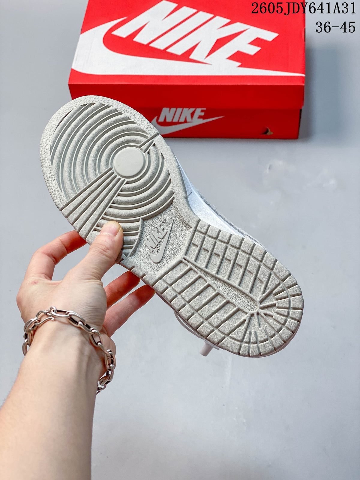 Outsole view of a low-top sneaker with circular tread and a red shoebox in the background