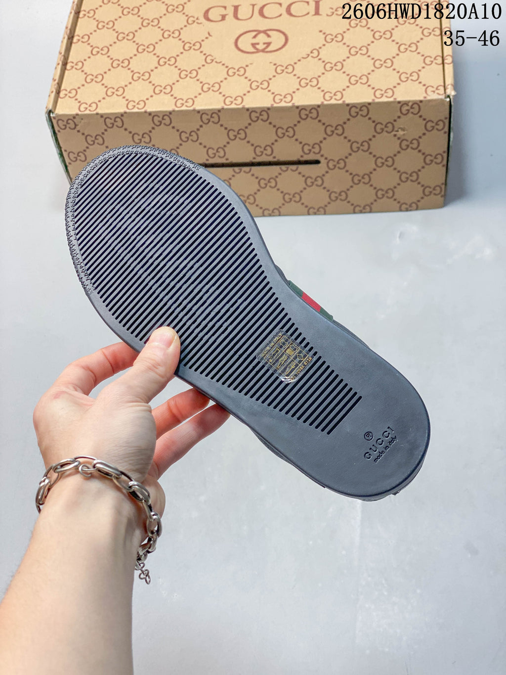 View of the dark outsole with narrow grooves, with the sneaker box in the background.
