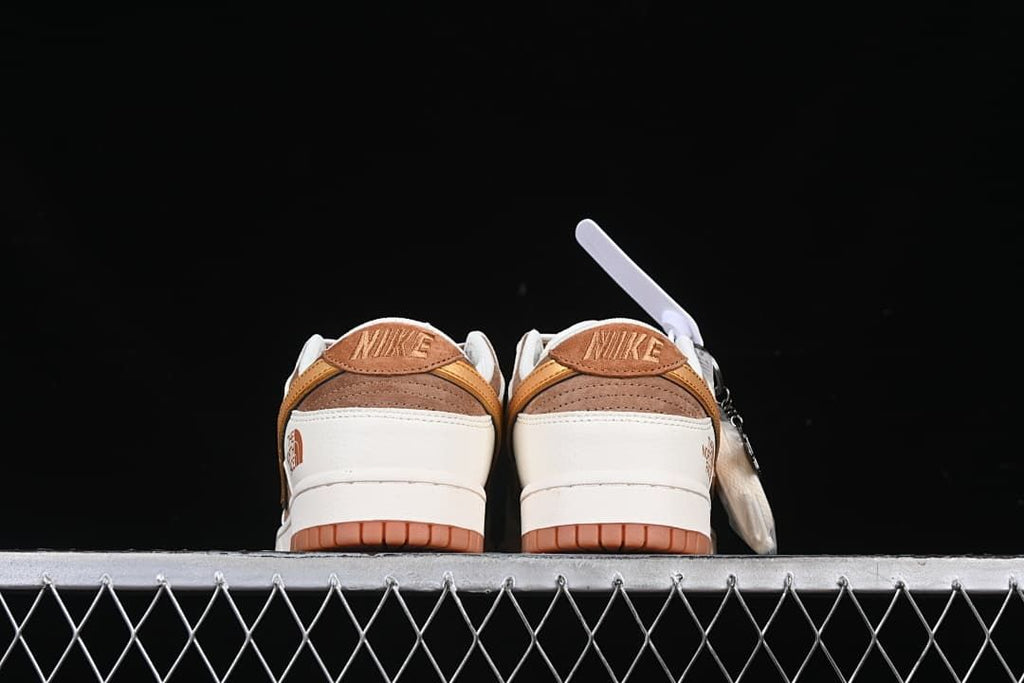 Rear view of both sneakers with brown heel panels and gum-colored outsoles