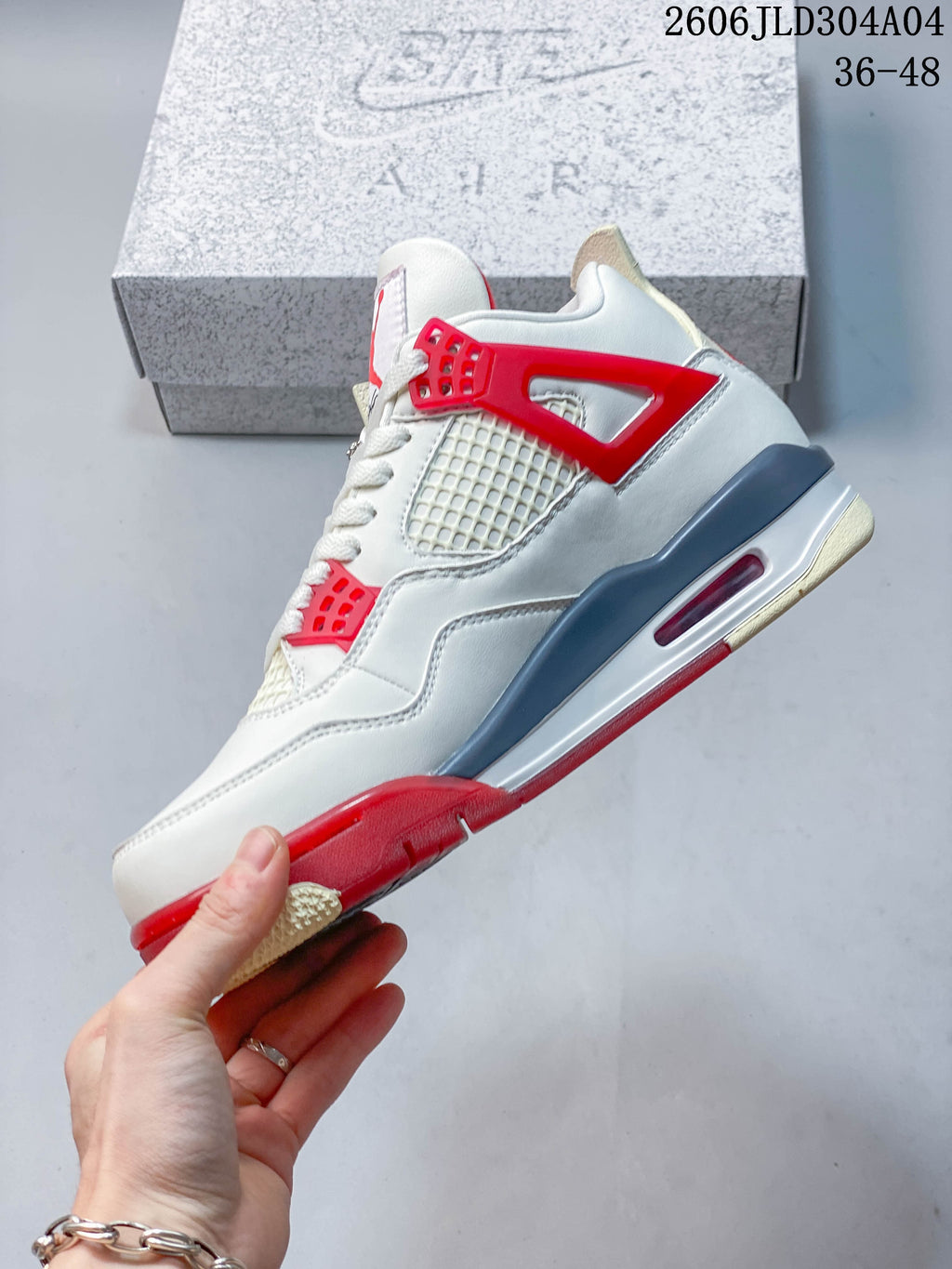 Side view of the white mid-top sneaker with red accents and mesh panels