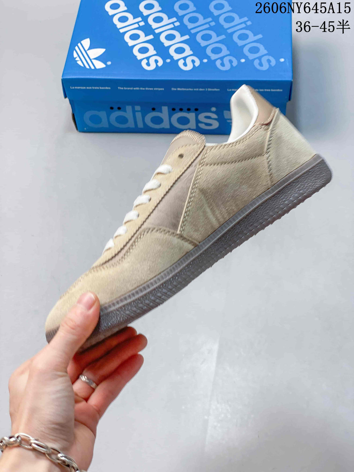 Side view of the taupe low-top sneaker with white laces and a gum-colored sole.