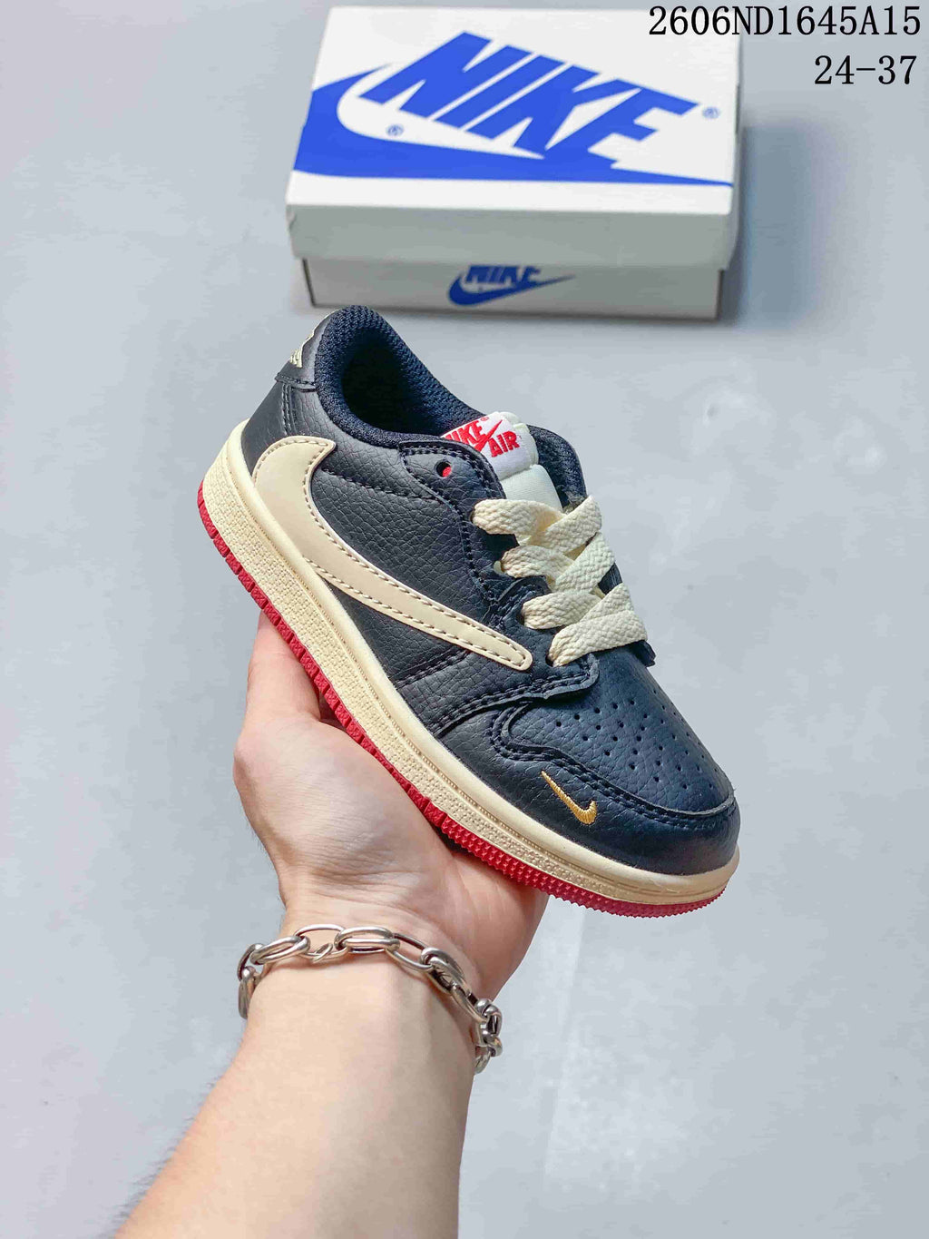 Angled side view of the dark navy sneaker with cream accents and a red outsole