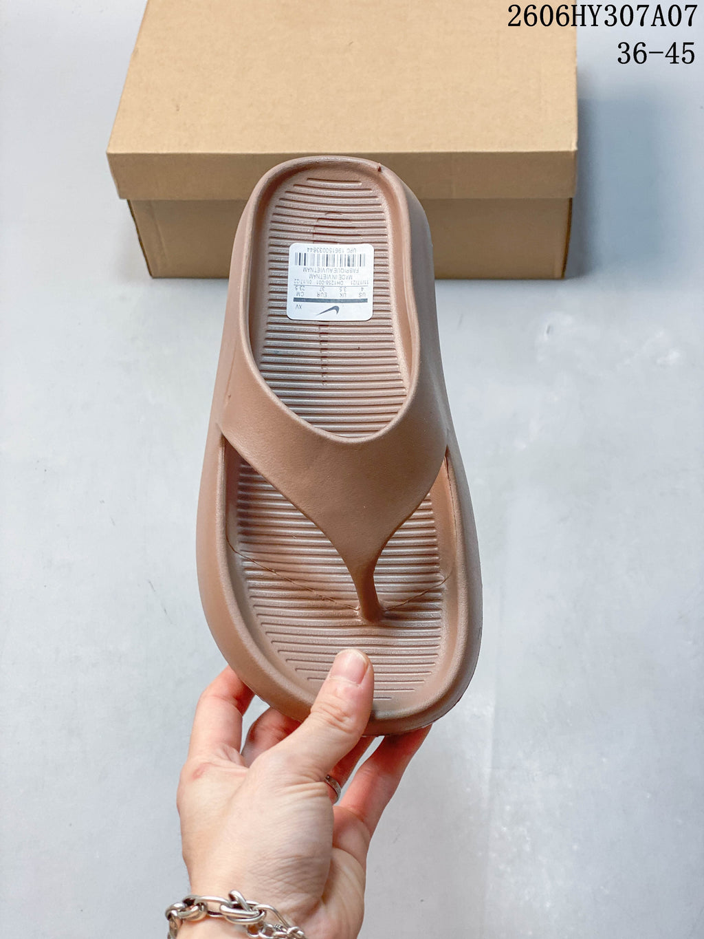 Top view of a taupe thong-style slide sandal with a ribbed footbed and visible size label; image overlay shows sizes 36–45 and style code 2606HY307A07.