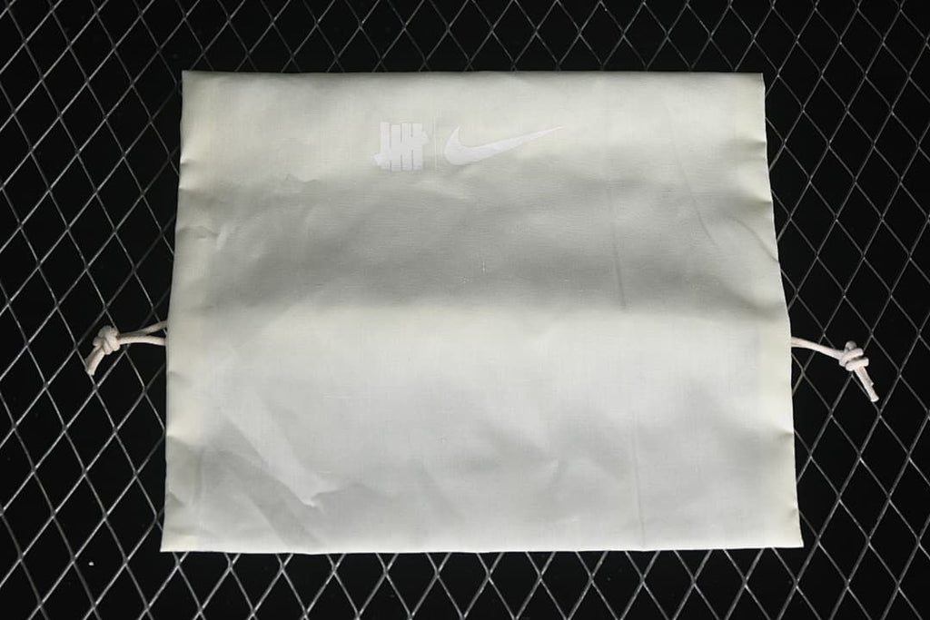 White drawstring bag with Undefeated and Nike logos.