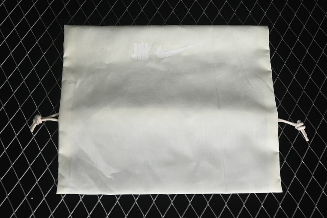 White drawstring bag with Undefeated and Nike logos.