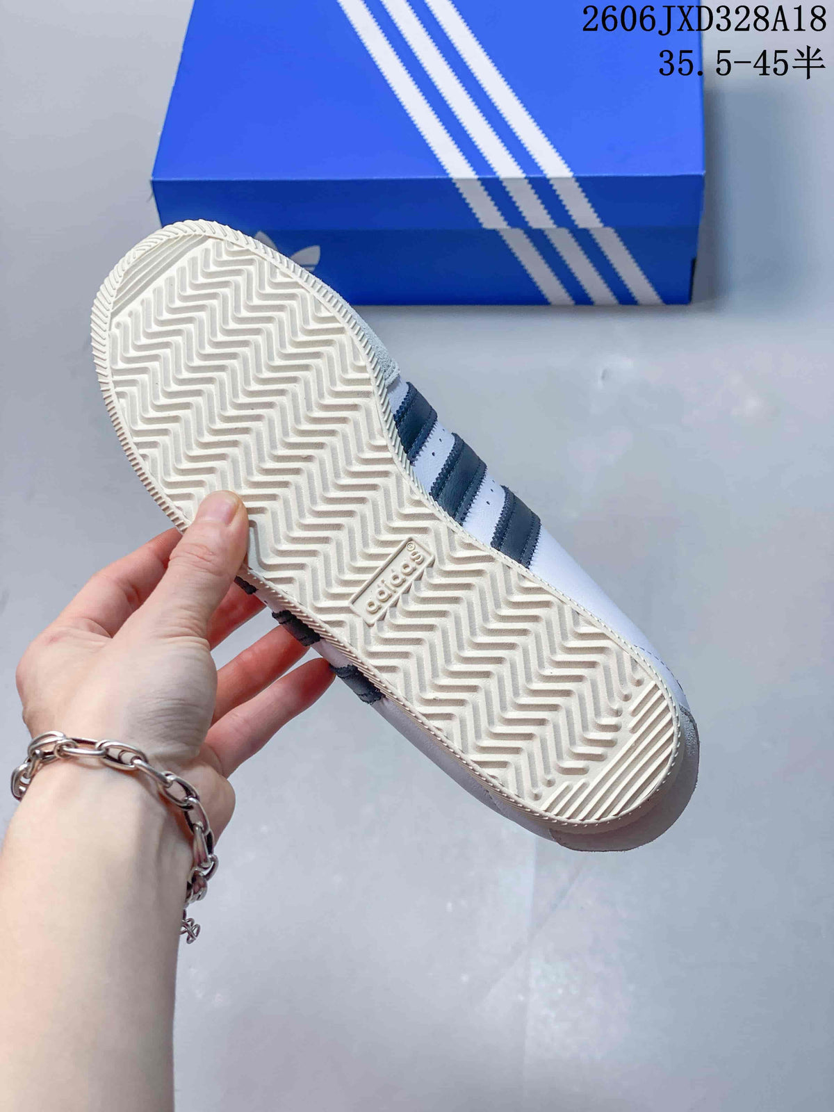 Underside of the sneaker showing a patterned outsole and dark side stripes