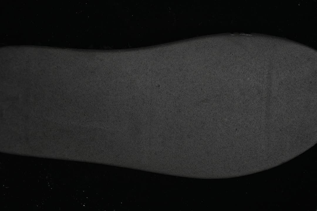 Dark close-up view of the shoe's outsole.