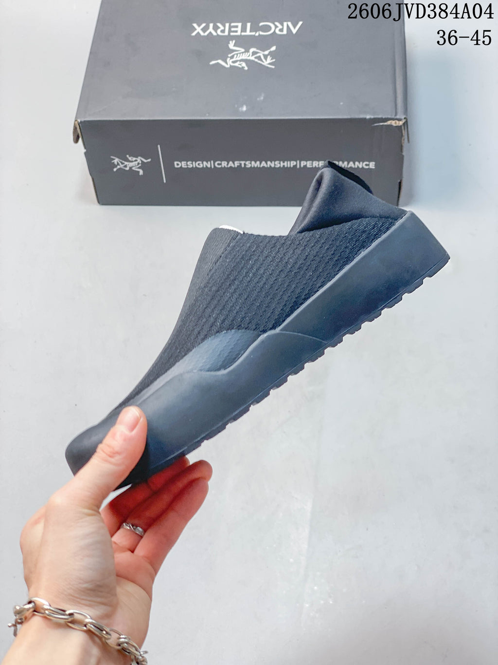 Side profile of a dark gray slip-on shoe with a wraparound sole