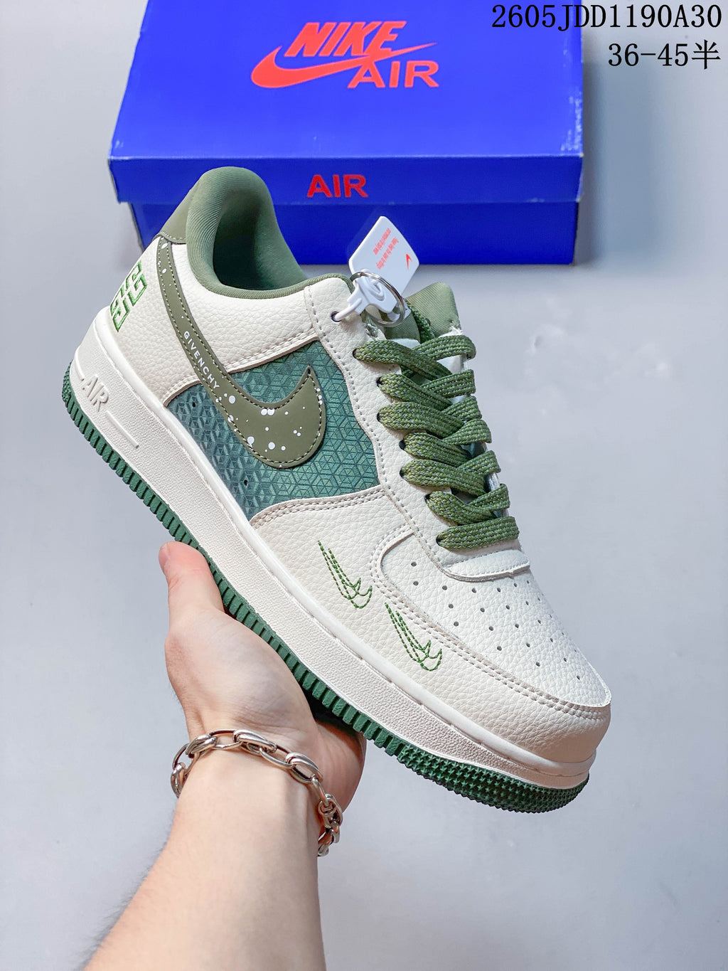 Side view of a white sneaker with green patterned panels, olive accents, and green outsole details
