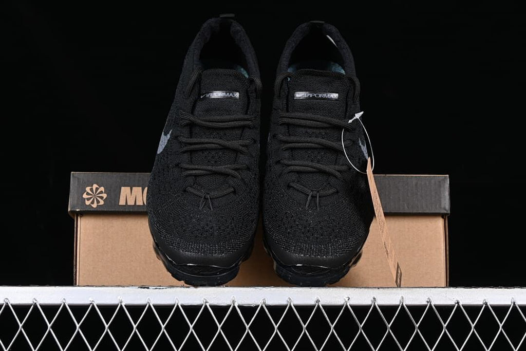 Front view of the pair of black sneakers with gray Swoosh details