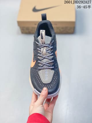 Top view of a dark gray and orange Nike trail running shoe with patterned laces and a visible Swoosh.